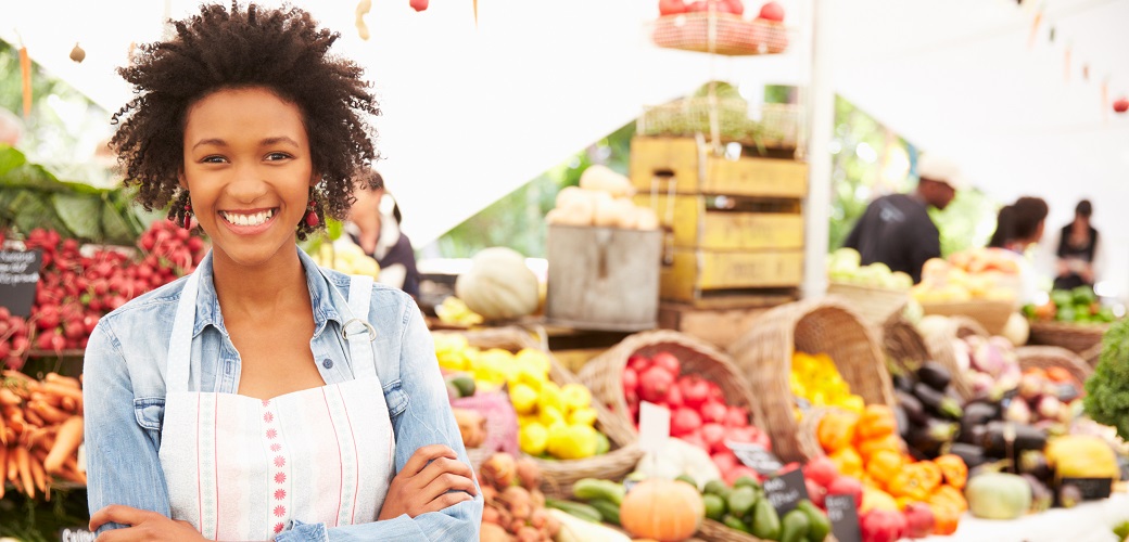 woman next to vegetable display