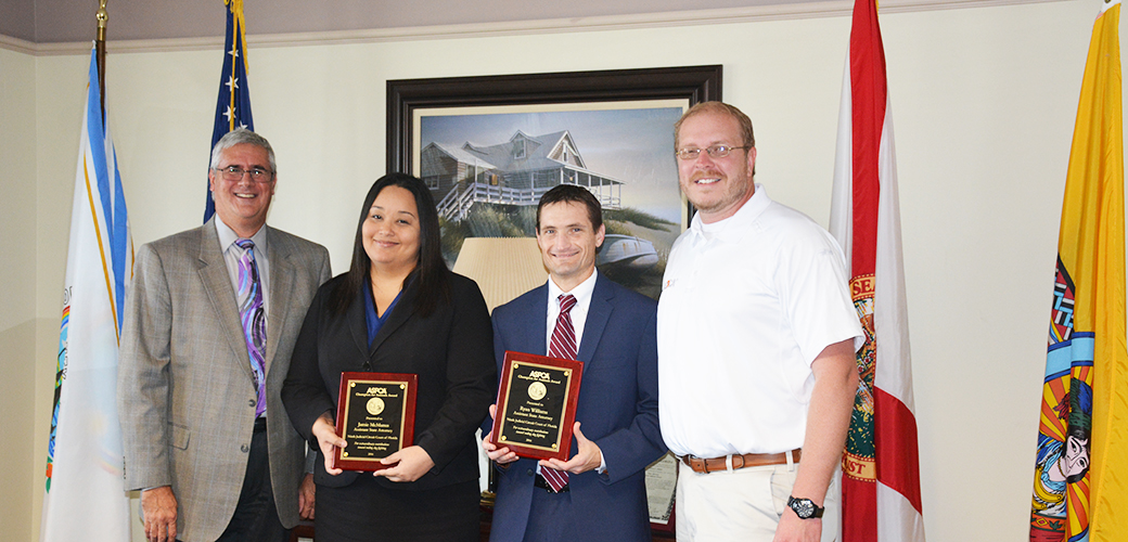 Florida assistant state attorneys Jamie McManus and Ryan Williams receive their “Champion For Animals” award.]