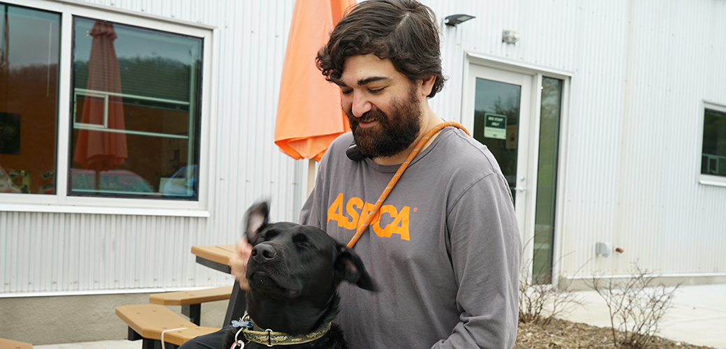 ASPCA staff member with a black dog