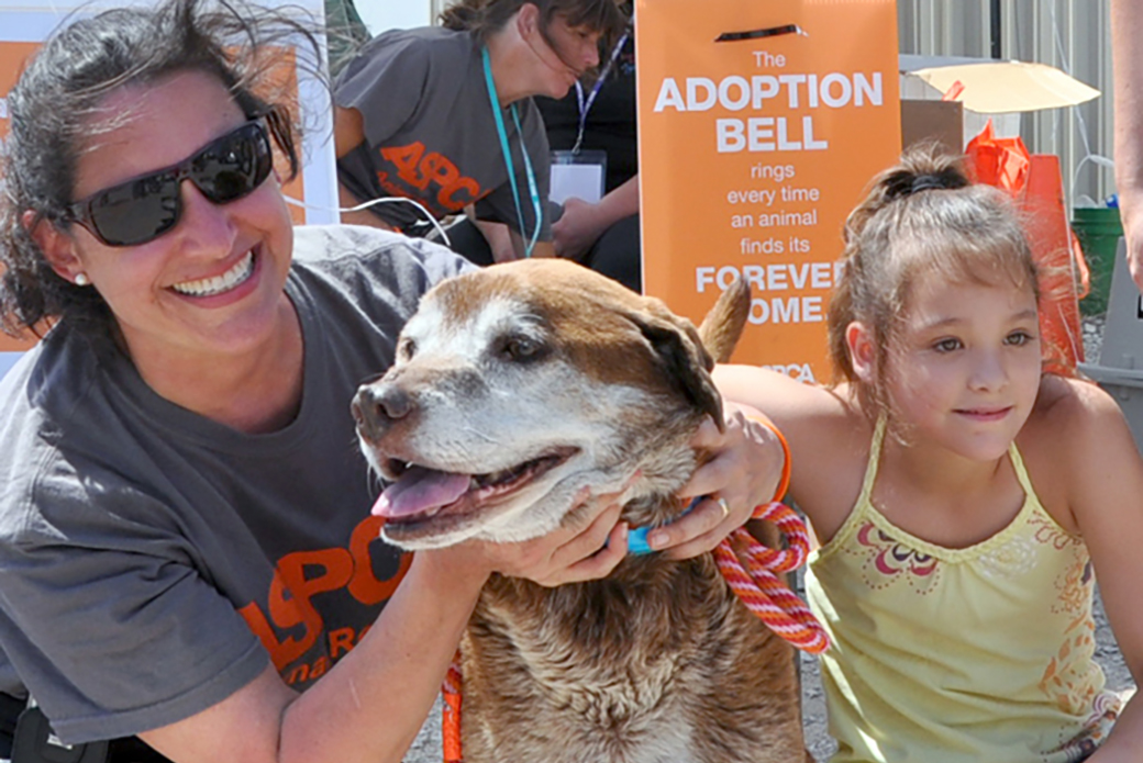 a girl with her rescued dog and an aspca responder