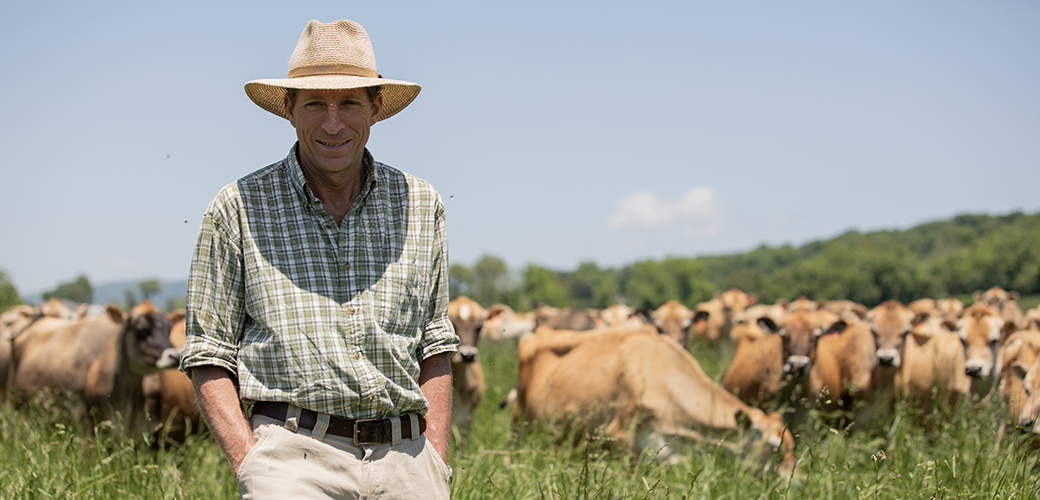 A farmer in front of grazing cattle