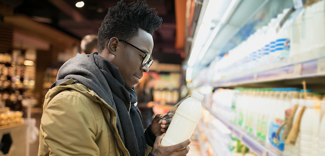 a man looking at milk in a grocery store