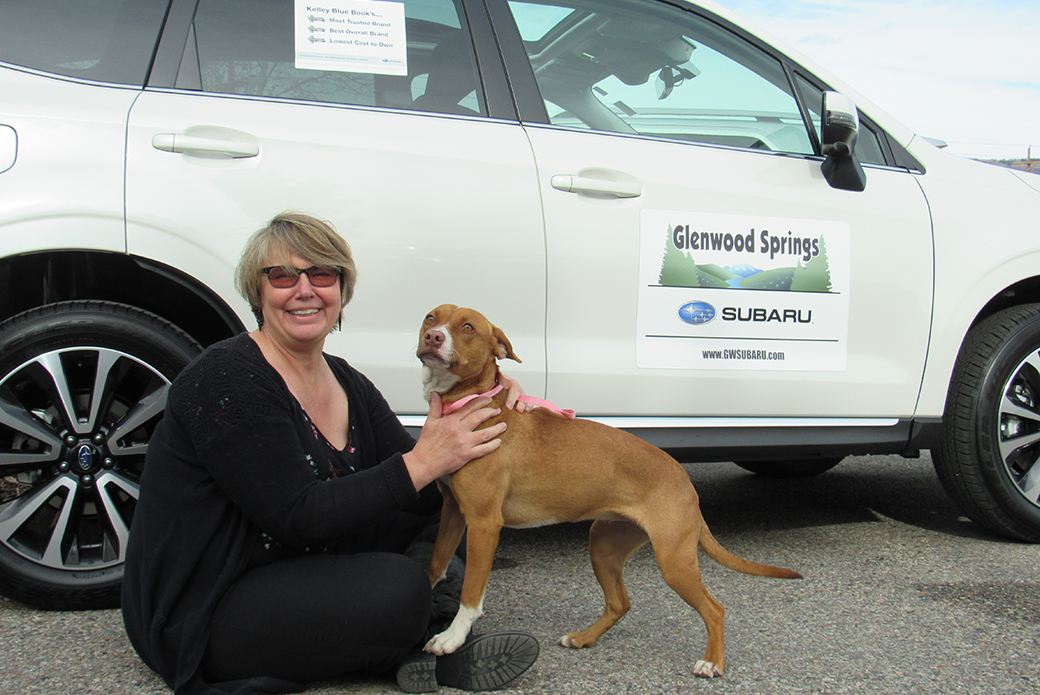 a woman and her dog at a subaru share the love event