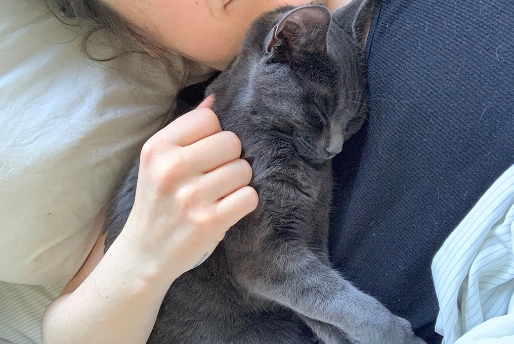 a woman cuddling a sleeping cat