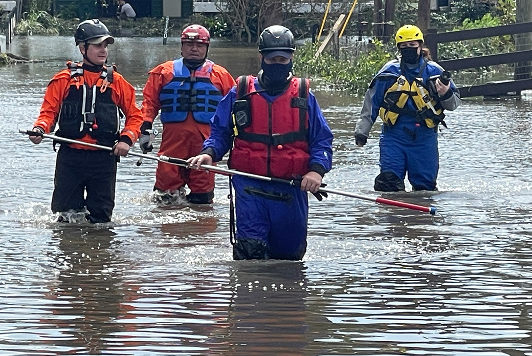 Responders wading through water