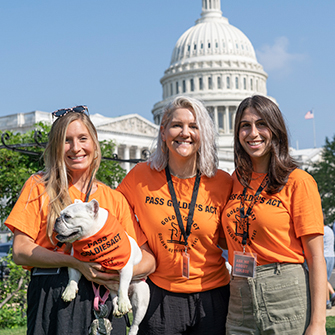 Three women and a white bulldog at Howl at the Hill event